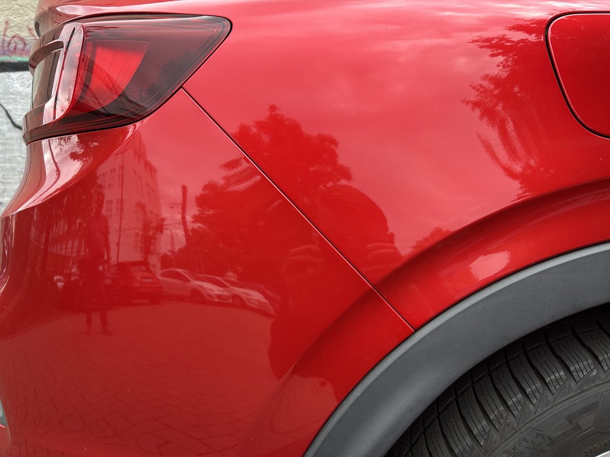 Beschädigte Heckpartie eines roten Renault Arkana mit eingedrückter Stoßfängerabdeckung, Schadenhöhe 5.060,37 €
